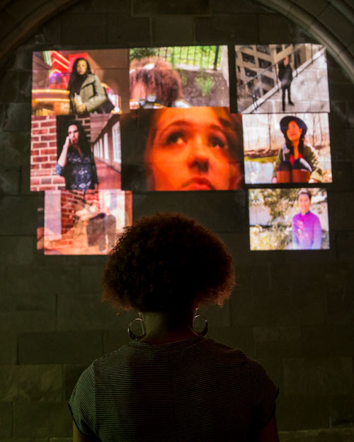 a person looking at a projector screen that is showing some photos